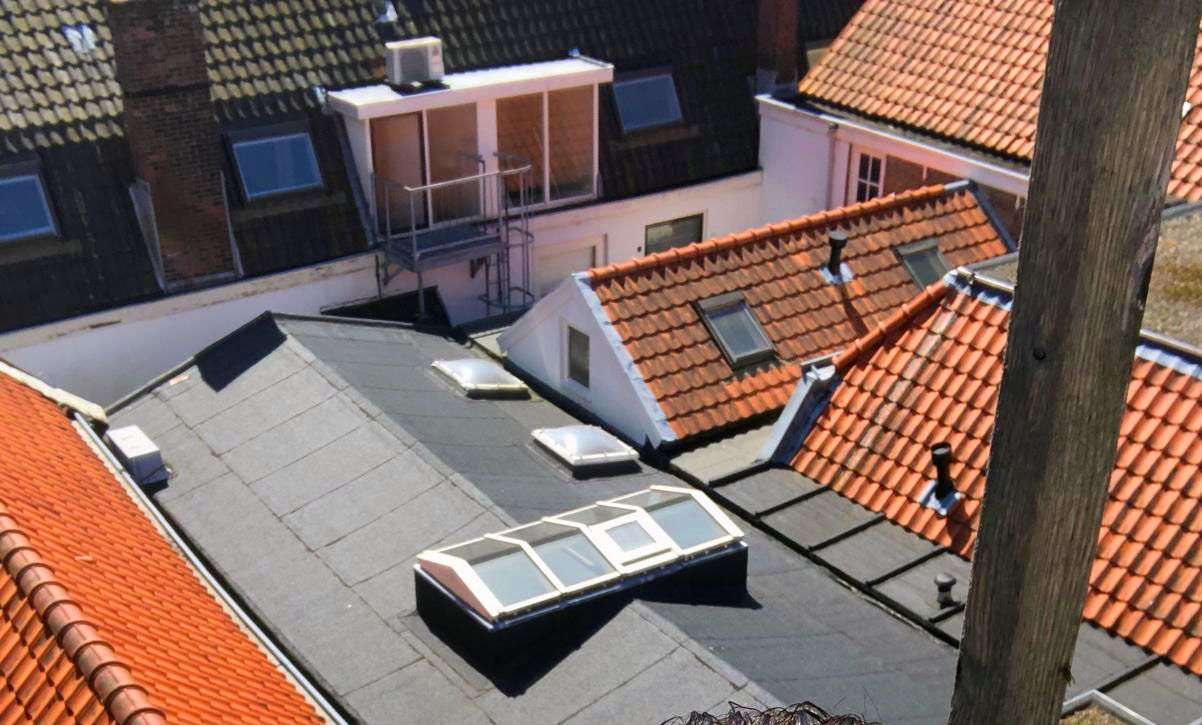 Platte daken en pannendaken in een oude binnenstad, van boven gezien