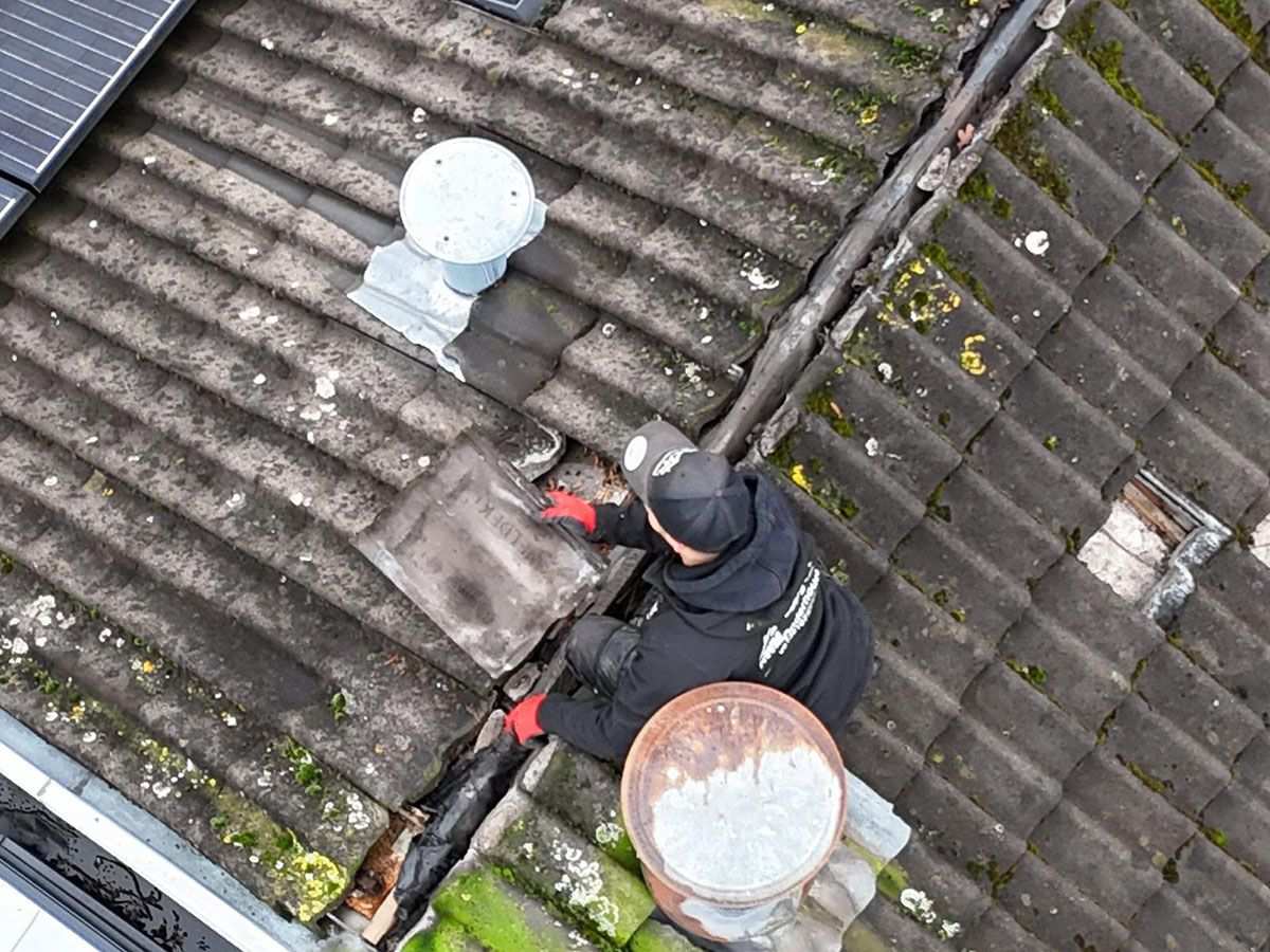 Dakdekker zoekt een lekkage op een pannendak